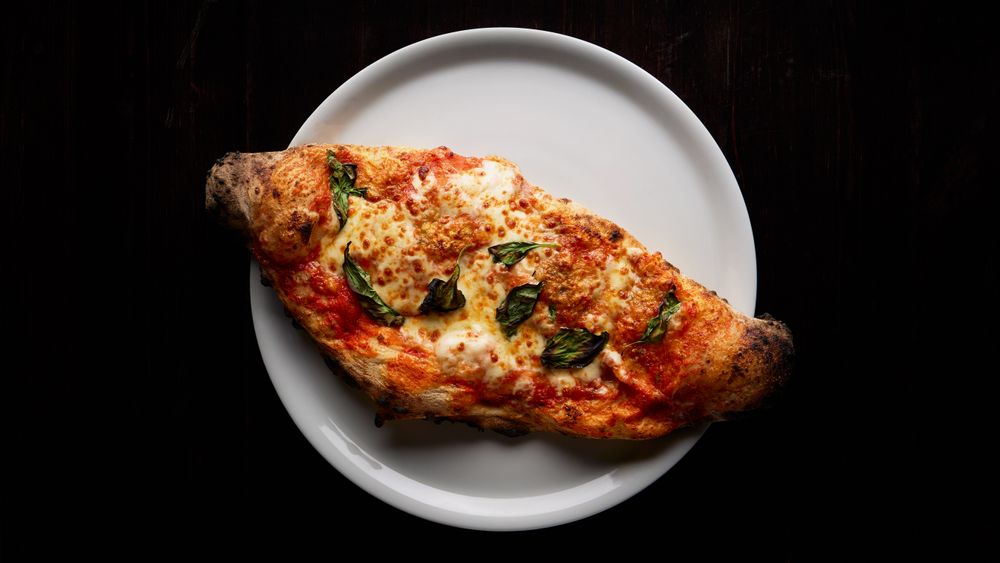 Calzone farcito appena sfornato su piatto bianco