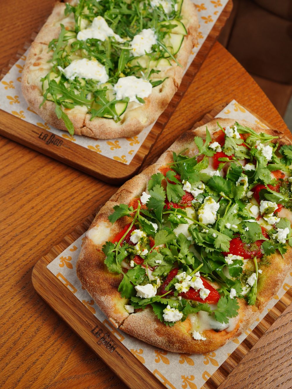 Due pinse romane con verdure fresche su taglieri di legno