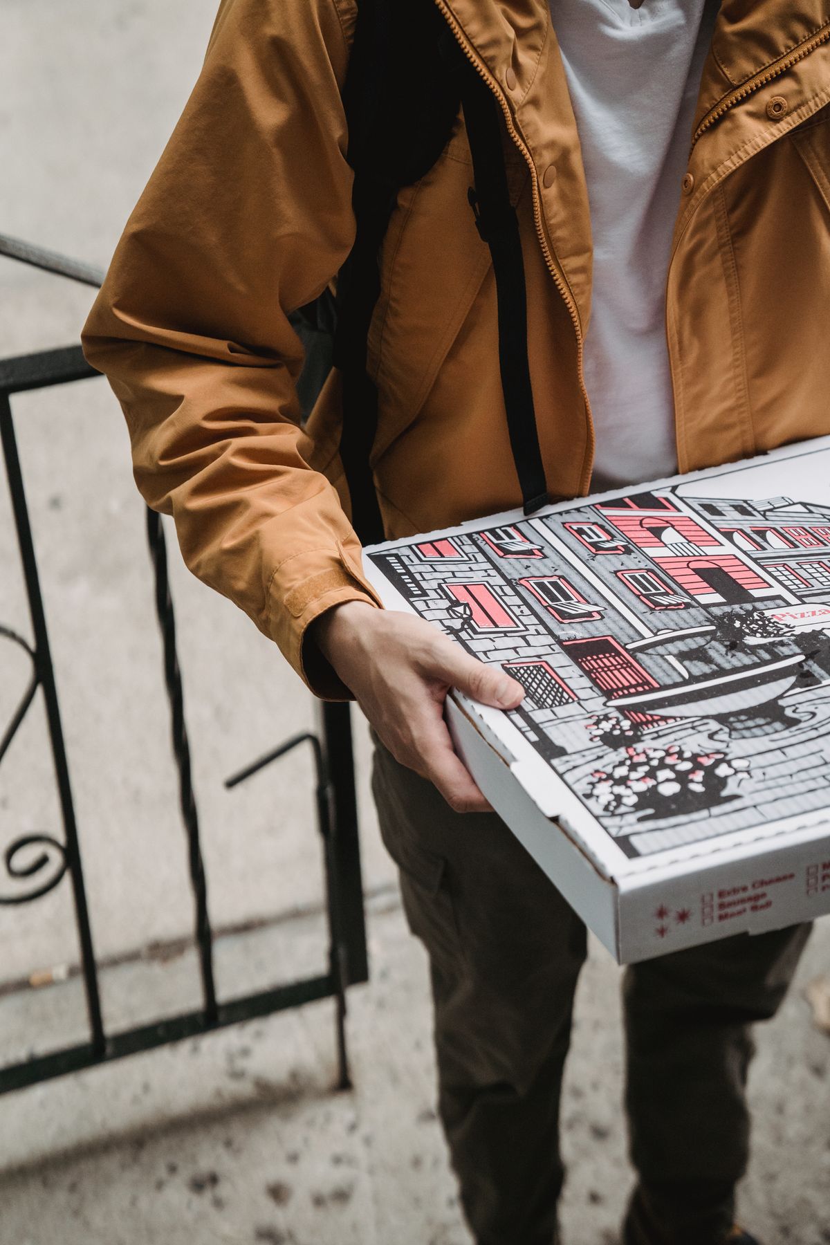 Fattorino che consegna una pizza nel cartone