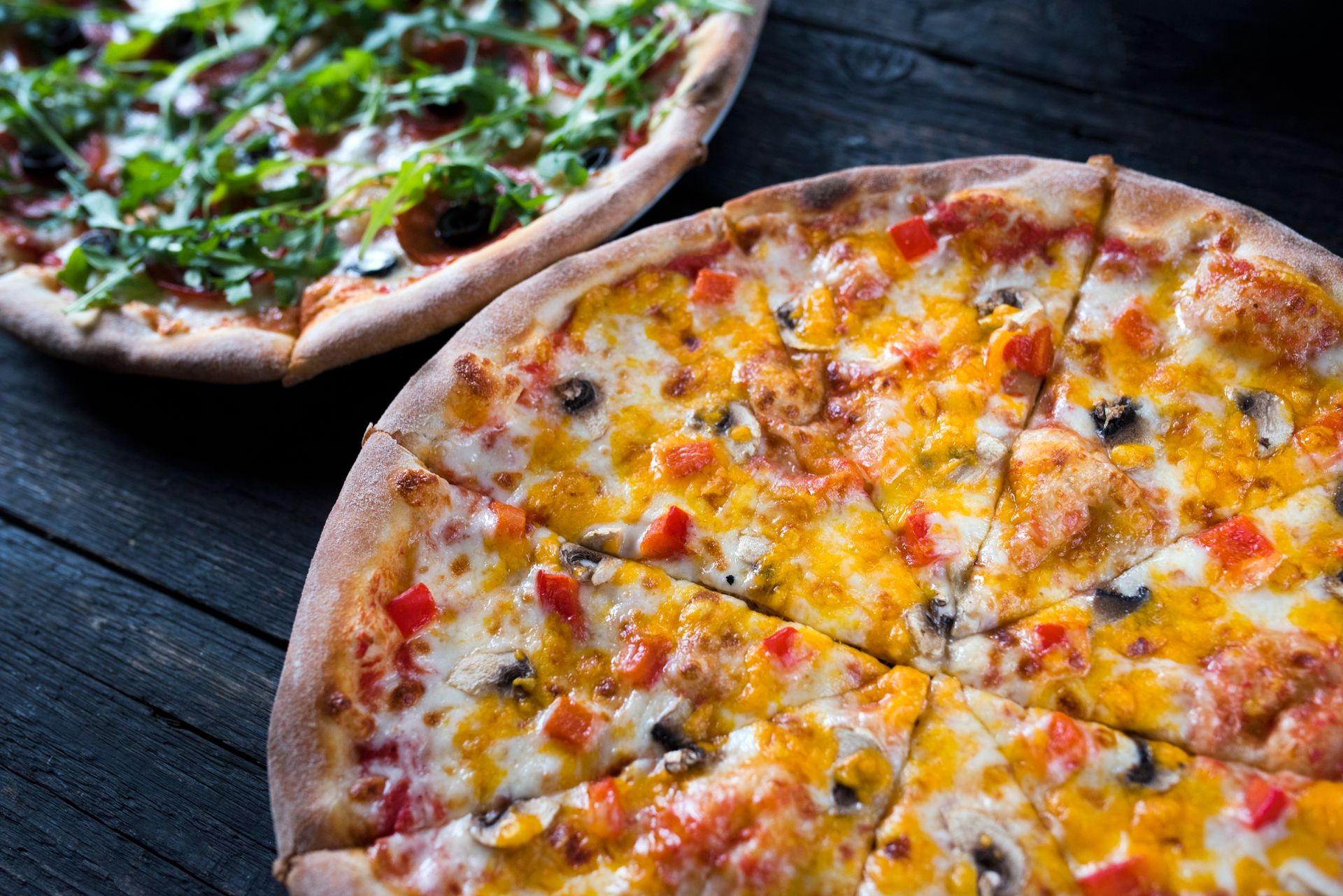 Pizze appena sfornate su un tavolo scuro